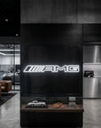 Néon LED mural logo AMG allumé dans un showroom, déco garage voiture sportive