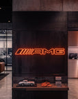 Néon LED mural logo AMG allumé dans un showroom, déco garage voiture sportive
