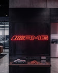 Néon LED mural logo AMG allumé dans un showroom, déco garage voiture sportive