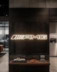 Néon LED mural logo AMG allumé dans un showroom, déco garage voiture sportive