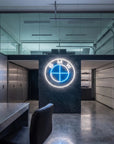 Néon LED mural logo BMW allumé dans un garage, déco voiture sportive