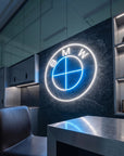 Néon LED mural logo BMW allumé dans un garage, déco voiture sportive