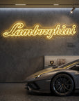 Néon LED mural logo Lamborghini allumé dans un garage, déco supercar italienne