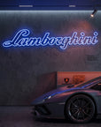 Néon LED mural logo Lamborghini allumé dans un garage, déco supercar italienne