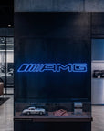Néon LED mural logo AMG allumé dans un showroom, déco garage voiture sportive