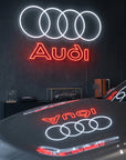 Néon LED mural logo Audi quatre anneaux allumé dans un showroom, déco garage