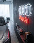 Néon LED mural logo Audi quatre anneaux allumé dans un showroom, déco garage