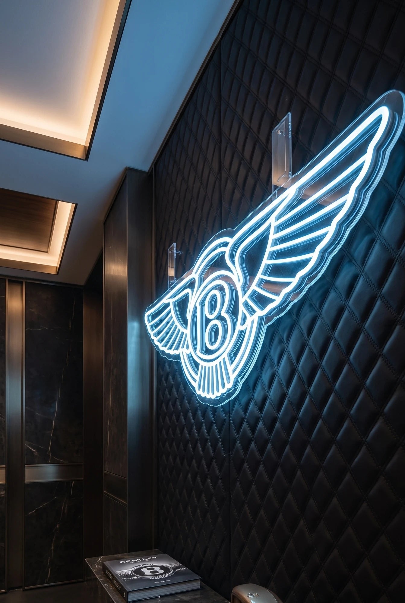 Néon LED mural logo Bentley B ailé allumé dans un intérieur luxe, déco GT