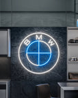 Néon LED mural logo BMW allumé dans un garage, déco voiture sportive