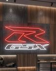 Néon LED mural logo Suzuki GSX-R allumé dans un garage moto, déco motard