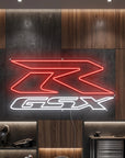 Néon LED mural logo Suzuki GSX-R allumé dans un garage moto, déco motard