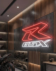 Néon LED mural logo Suzuki GSX-R allumé dans un garage moto, déco motard