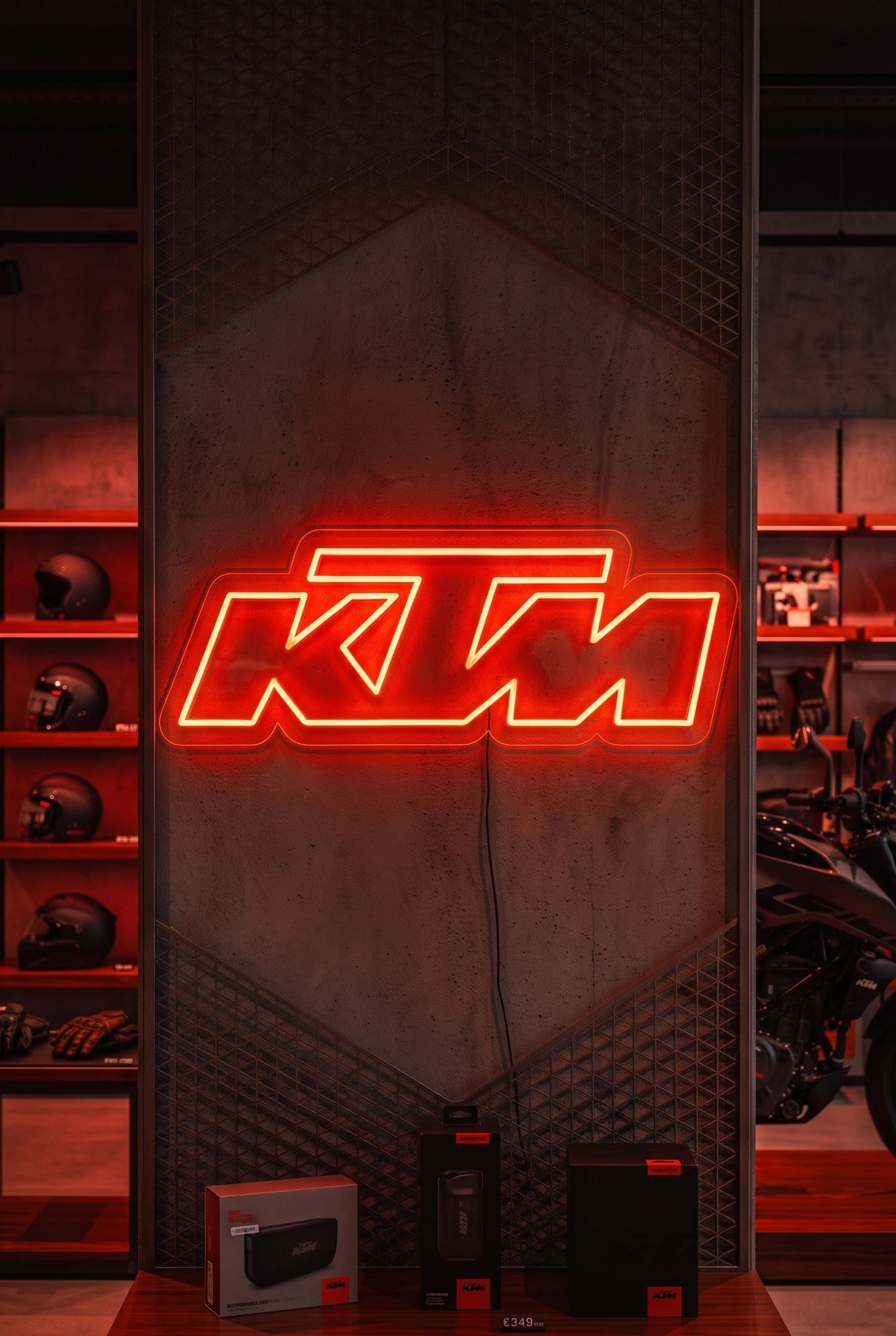 Néon LED mural logo KTM allumé dans un magasin moto, déco garage motard