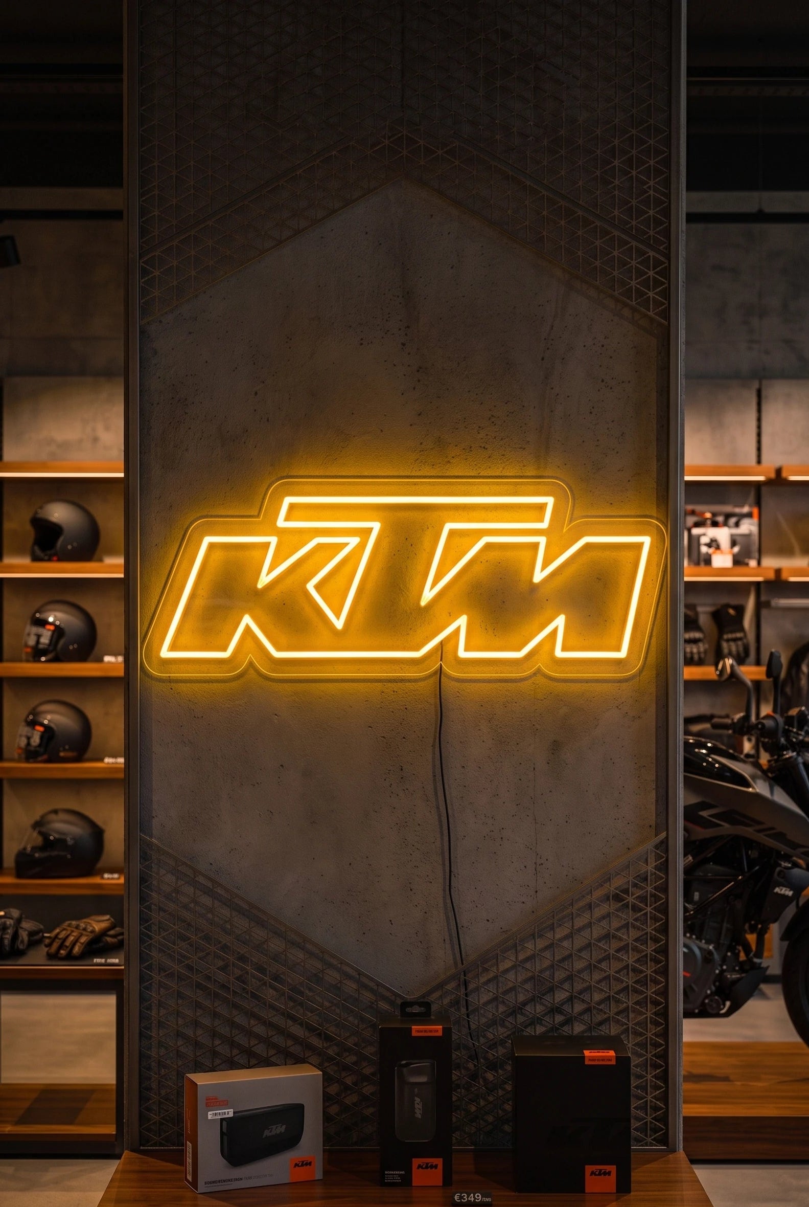 Néon LED mural logo KTM allumé dans un magasin moto, déco garage motard