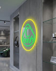 Néon LED mural logo Lotus allumé dans un intérieur, déco garage voiture de sport